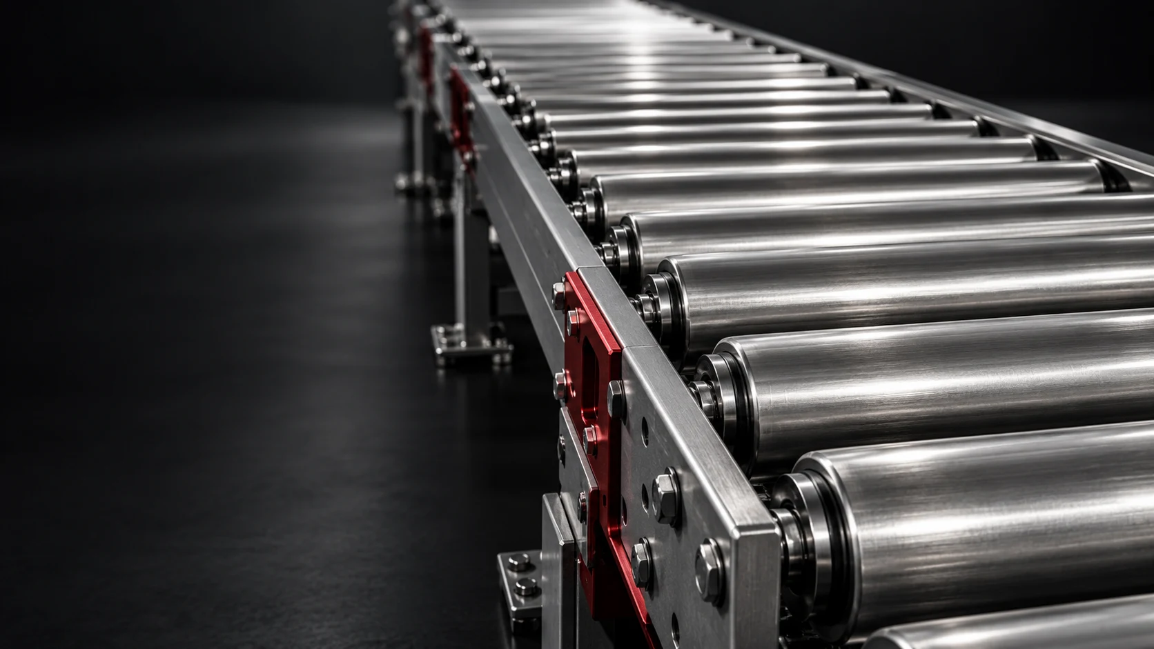 Close-up of brushed stainless-steel conveyor rollers and precision-machined supports